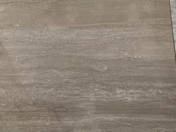 A cut sample of the light coffee board: a pale warm beige with soft straight veining running across it, photographed on a white bench.