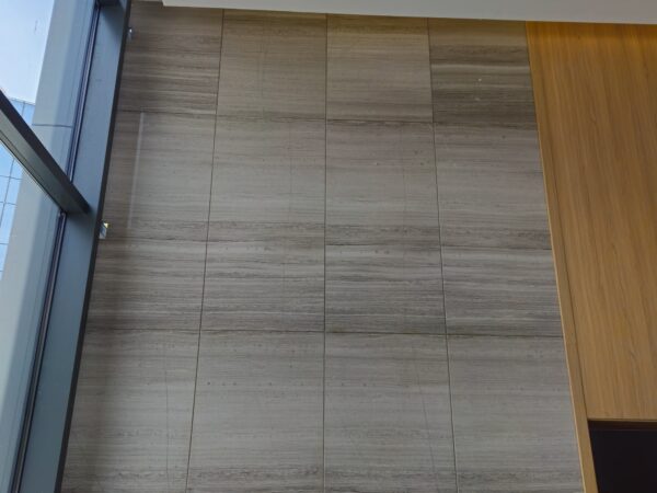 A floor of this stone laid in a run beside a glazed wall, the boards laid with the figure along the length of the space.
