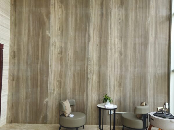 The same clad wall seen from the other end, the joints running vertically between the boards and the light falling down the face.