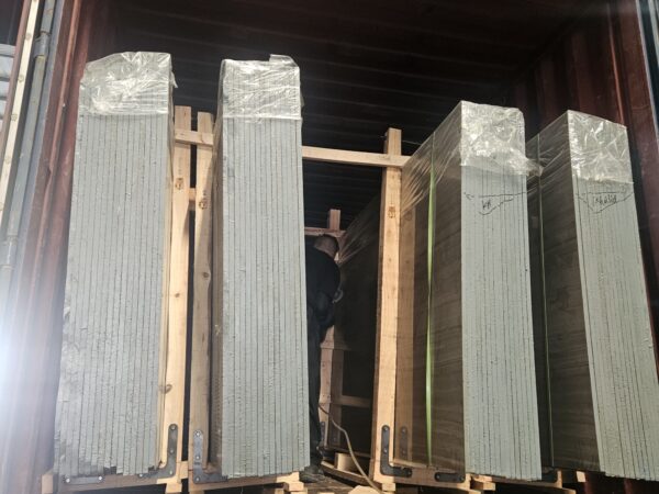 Slabs being loaded into a container, standing on edge in the A-frame.