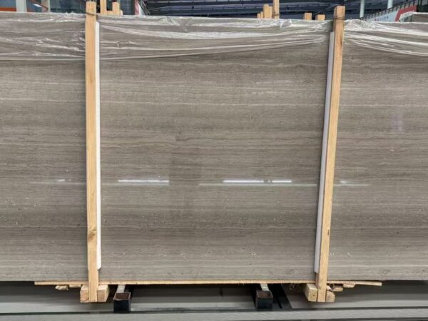 Three slabs wrapped in film in the workshop, banded in their timber frame.