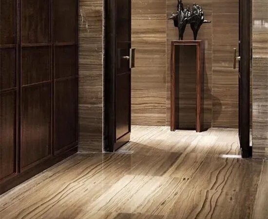 A finished interior with dark wood-grain stone cladding on the walls, a matching stone floor, dark doors and a black sculpture on a plinth